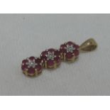 A 9ct gold pendant comprising of three ruby and diamond clusters