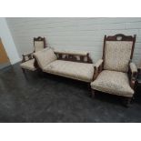 A late Victorian mahogany frame salon suite, comprising ladies and gents armchairs, having crest