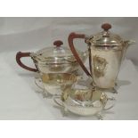 A silver four piece tea set of boat form having moulded decoration to rims, quatrefoil lion mask