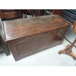 An 18th century oak coffer having panel sides and stile supports