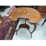 An Edwardian mahogany occasional table of tiered kidney design on shaped legs