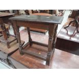An early 20th century dark oak joint stool in the Jacobean style having rectangular top on