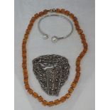 An Indian white metal multi chain bracelet having a filligree clasp, a string of amber coloured