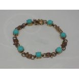 A 9ct gold bracelet having seven turquoise style stones in claw set collared mounts with moulded