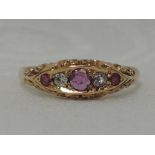 A lady's dress ring having three rubies interspersed by a diamond and replacement white stone in a