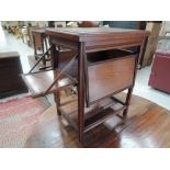 An Edwardian mahogany occasional table having rectangular swivel top and four tray flaps under