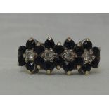 A lady's dress ring having four interlocking sapphire and cubic zirconia clusters in raised claw