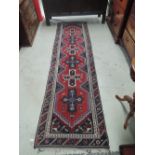 A late 20th century carpet runner of Turkmen design having red and blue ground, 295 x 78cm