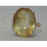 A lady's dress ring having an oval citrine in four claw raised mount on a yellow metal loop