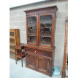 A Victorian mahogany full height bookcase having glazed top over drawer and cupboard base