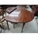An early 20th century mahogany dining table in the George II style having oval drop leaf top on