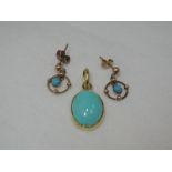 A turquoise style oval pendant in a yellow metal collared mount with similar earrings in 9ct gold