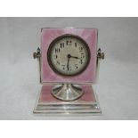 An Art Deco silver desk clock having pink guilloche enamel decoration and swing fitting,