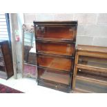 An early 20th century dark oak four tier stacking bookcase