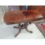 An early Victorian scumbled walnut top tea table having twist fold over top on quadrafoil columns