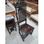 A 19th century dark oak hall chair in the Jacobean style, having baluster, slat and crest back