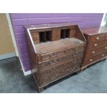 A 19th century oak bureau having later extensive carved scroll and roundel decoration, with fitted