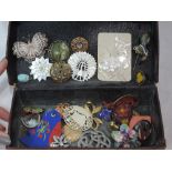 A vintage leather box containing a selection of brooches including filligree and mother of pearl