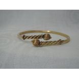 A yellow metal Victorian style torque bracelet having ball ends, marks worn, probably 9ct