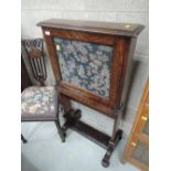 A late Victorian oak escritoire having open top with tapestry panel and brass scorce on slender