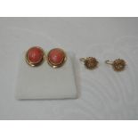 A pair of oval coral stud earrings in yellow metal collared mounts stamped 750, and a pair of