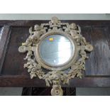 A vintage cast metal wall mirror having Heraldic crest and puttie decoration