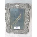 An Edwardian silver photograph frame having scroll and trellis decoration and velvet easel back,