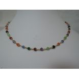 A yellow metal necklace having multi coloured beads with chain interlinks, stamped 750, approx 22'