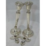 A pair of silver candlesticks having square tapered stems to weighted circular bases, Birmingham