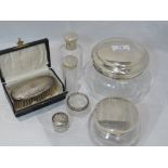 Two glass dressing table powder pots with HM silver lids, three glass dressing table pots with HM