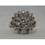 A lady's dress ring having a cubic zirconia triple cluster in a claw set basket mount on a 9ct