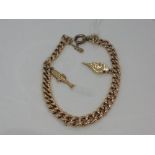 A 9ct rose gold curb link bracelet having two charms and a replacement clasp