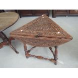 A late 19th/early 20th century oak occasional table having tri form drop leaf carved top on baluster