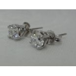 A pair of diamond solitaire stud earrings, each approx 0.75ct in 4 claw white metal mounts, no marks