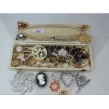 A small selection of costume jewellery including brooches, gold plated bangle and identity