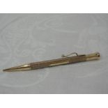 A 9ct gold propelling pencil by The Mascot Reg having engine turned decoration