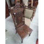 A late Victorian dark oak craftsman hall chair having bobbin carved back with oak leaf detail,