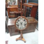 A mid Victorian part mahogany polescreen having oval embroidered adjustable top and triform base