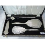 A cased silver four piece dressing table set having floral and engine turned decoration,
