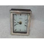 A modern HM silver framed clock having gadrooned rim, Roman numeral dial and wooden reverse