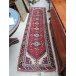 A traditional carpet runner having cream, red and blue ground