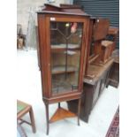 An Edwardian mahogany corner display cabinet having slender tiered stand under