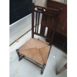 An Edwardian oak rocking chair having inlay decoration and rush seat