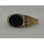 A 9ct gold signet ring having an oval black panel with shaped shoulders, size L/M