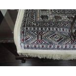 A modern carpet square of Bokhan design on cream and red ground, 90in x 63in