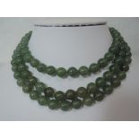 A three strand jadeite bead necklace of even form having an oval white metal and jade box clasp