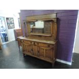 A late 19th century golden oak full height, mirror back sideboard having pillar support over drawers