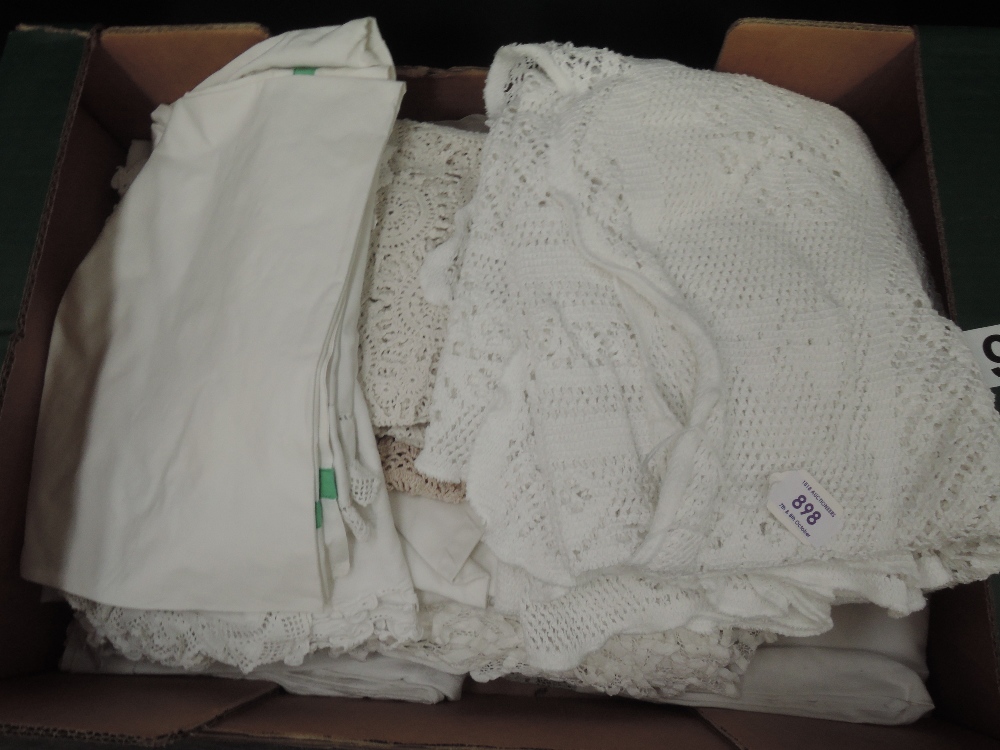 A box full of antique table linen and bed linen, including some intricately embroidered table