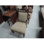 A late Victorian stained frame chair having crest and spindle back with later upholstery on turned