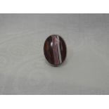 A lady's dress ring having a large striped oval orange agate in a collared mount on an HM silver